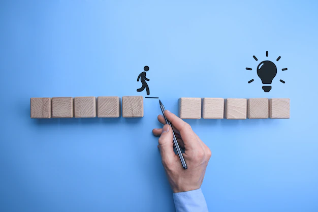 male-business-man-hand-drawing-connecting-line-two-sets-wooden-blocks-silhouetted-man-walk-across_150455-1882